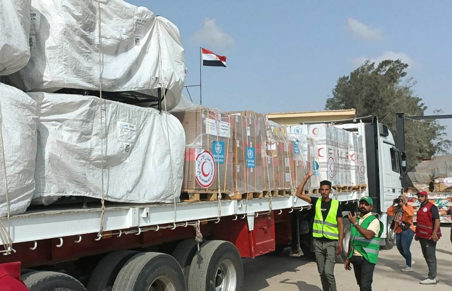 Egyptian Red Crescent members and volunteers gather next to a truck carrying humanitarian aid as it drives through the Rafah crossing from the Egyptian side, amid the ongoing conflict between Israel and the Palestinian Islamist group Hamas, in Rafah, Egypt October 22, 2023. REUTERS/Stringer